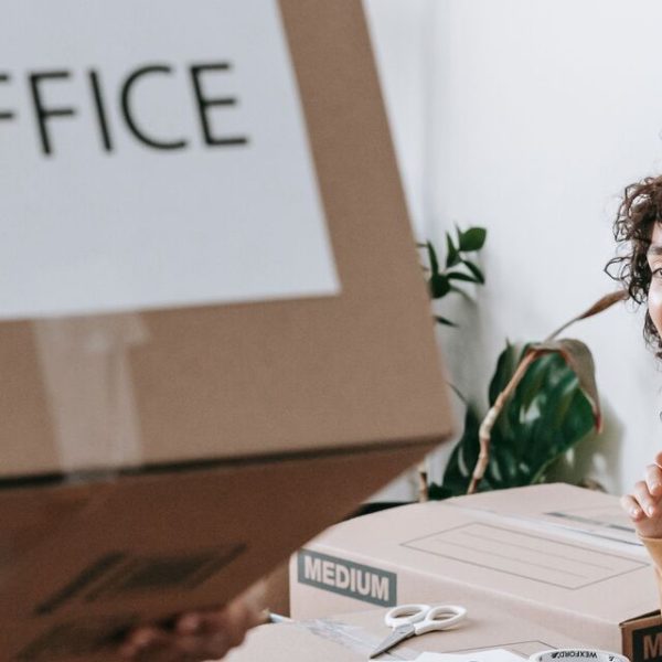 A man and woman in a room with moving boxes